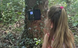 Kind bekijkt een wildcamera in de tuin als onderdeel van natuureducatie