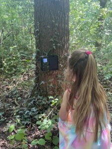 Kind bekijkt een wildcamera in de tuin – natuureducatie voor kinderen